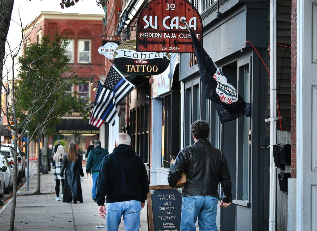 People walked along the downtown area in Plymouth filled with different businesses.